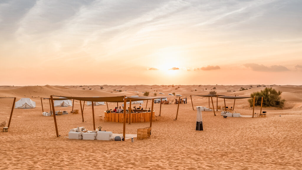 Golden hour sunlight over the desert dunes, the setting for Sonara Camp