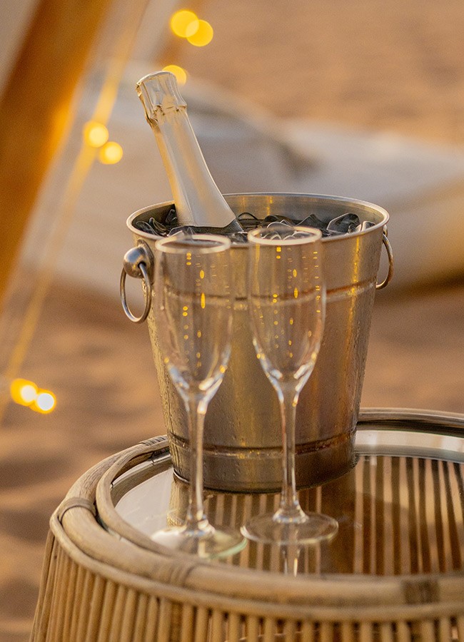 Champagne glasses at a private dinner with the Dubai desert sunset in the background