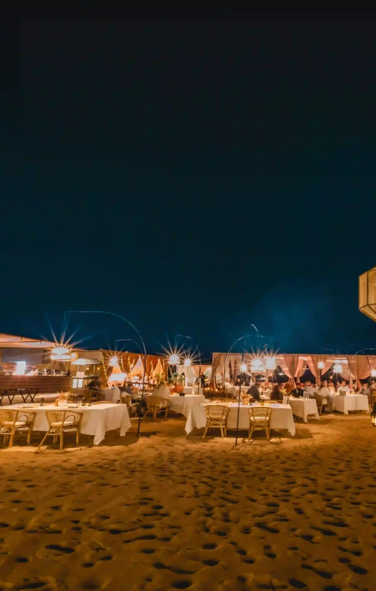 Guests enjoying a serene iftar setup in an Arabian desert camp under soft evening light during Ramadan Nights at Nara