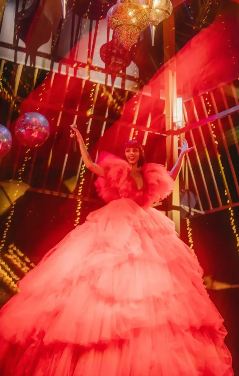 Stage performer in a red gown under decorative lighting during a Valentine’s evening event.
