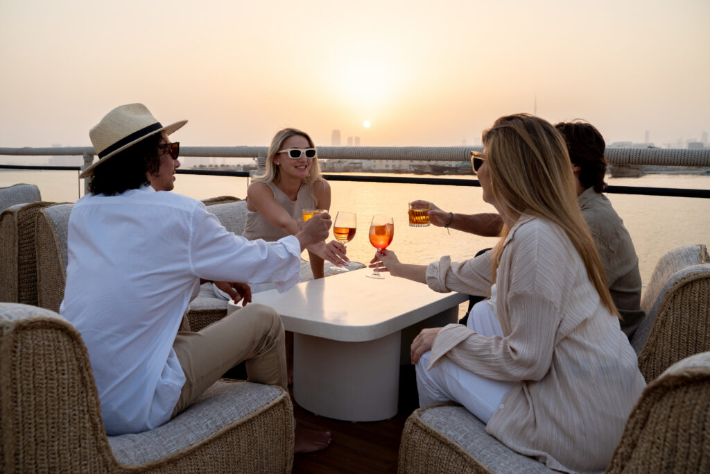 A group of 4 enjoying cocktails at sunset aboard Lady Nara in Dubai. 