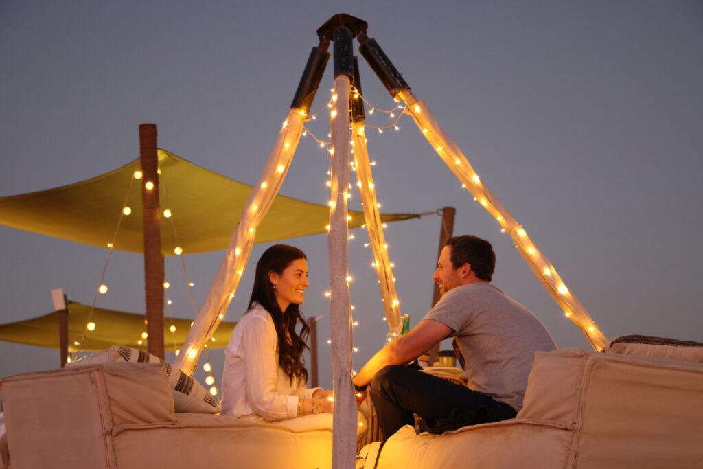 A couple sharing an intimate and private date under the stars at a Nara desert experience. 