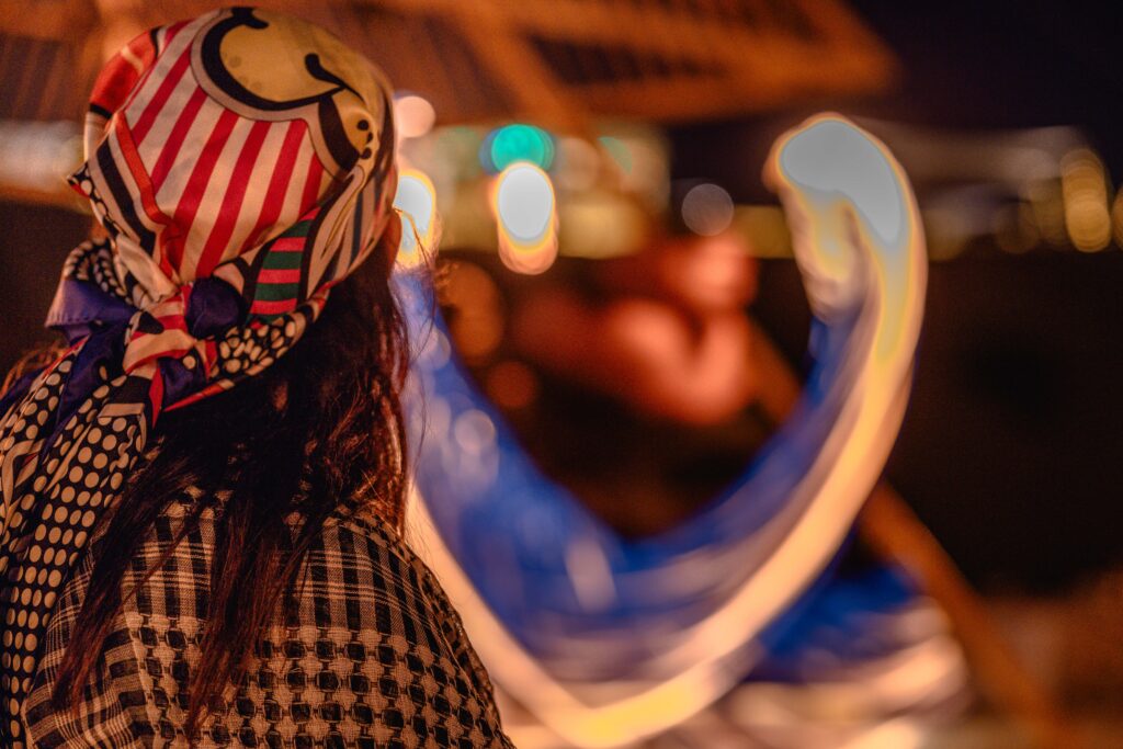 A woman looking at the performance on stage at Sonara Camp Dubai. 
