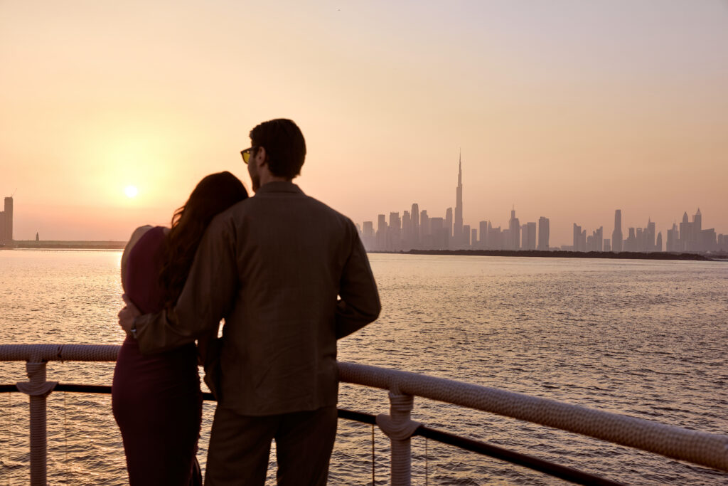 A couple looking over the Dubai skyline at sunset, aboard Lady Nara in Dubai. 